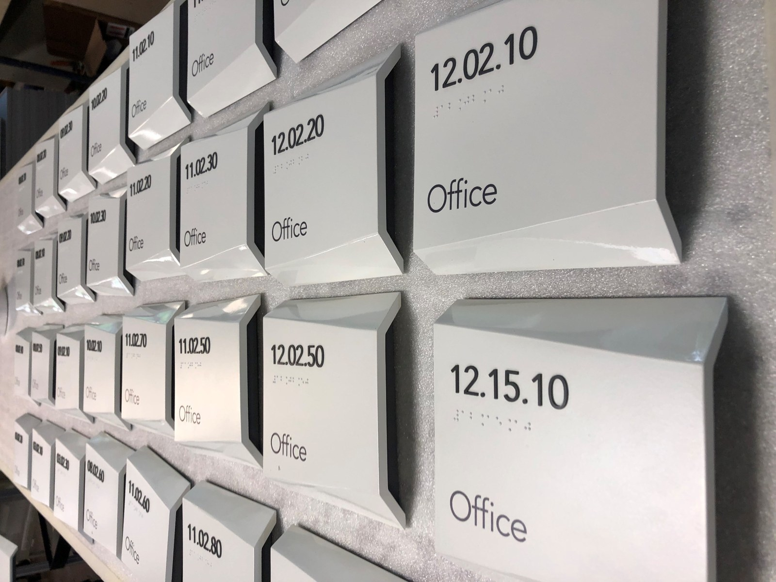 Rows of finished beveled office identification signs with room numbers, tactile lettering and Braille